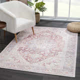 Living room scene with a Cream Rust Leeston Washable Rug, white chair, and woven ottoman. The rug has a vintage, oriental pattern. Roomscene-Rectangle