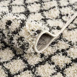 Close-up of the Muni Berber Shag Rug. Charcoal and light beige shag rug with a geometric Moroccan-inspired pattern. Fold