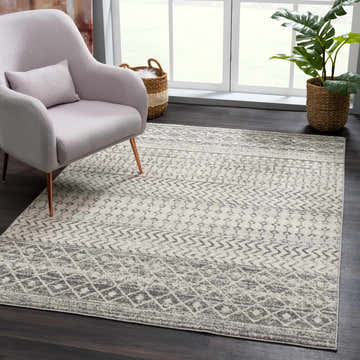 Living room scene with gray chair and New Harput Area Rug. Gray, light gray, and white geometric pattern. Roomscene-Rectangle