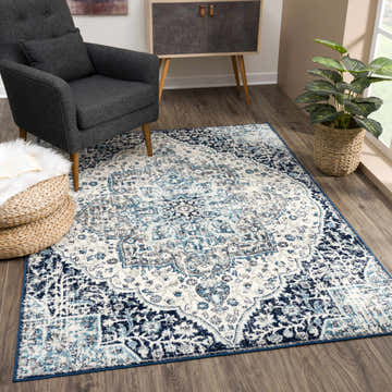 Living room scene with gray armchair and Marash KMRSH-4602 area rug in gray, ivory, navy, and turquoise. Roomscene-Rectangle
