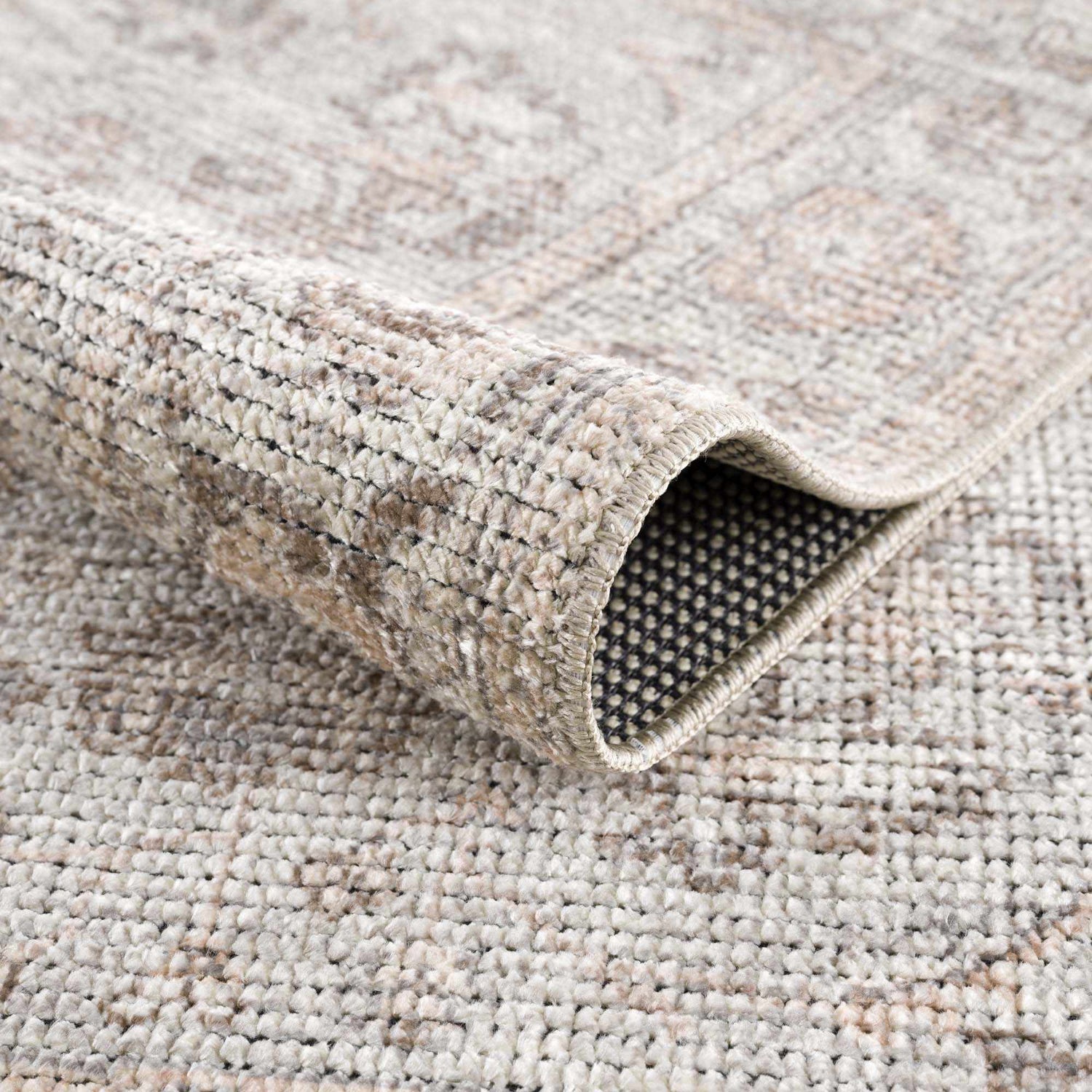 Close-up of the Niran Area Rug showing its traditional vintage pattern, polyester and cotton blend, and machine-woven construction. Fold