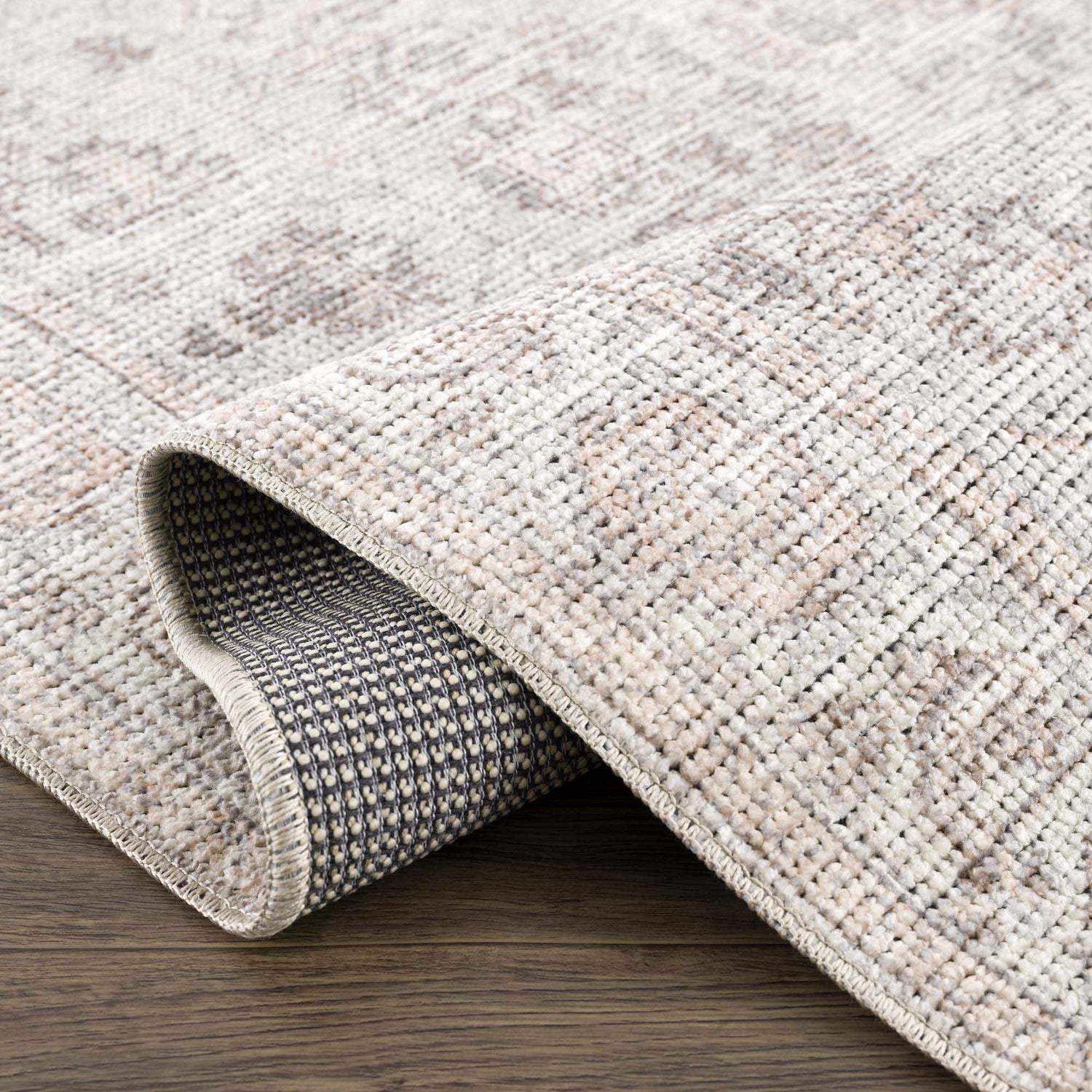 Close up of the Niran Area Rug showing its vintage pattern and woven texture. Fold