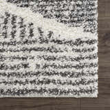 Close-up of the Trunding Plush Area Rug showing its charcoal and cream shag texture and bohemian pattern. Swatch
