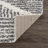Close-up of the Trunding Plush Area Rug showing its charcoal and cream shag texture and woven backing. Fold