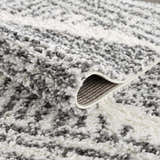 Close-up of the Trunding Plush Area Rug. Charcoal and cream shag rug with a plush, textured feel. Fold