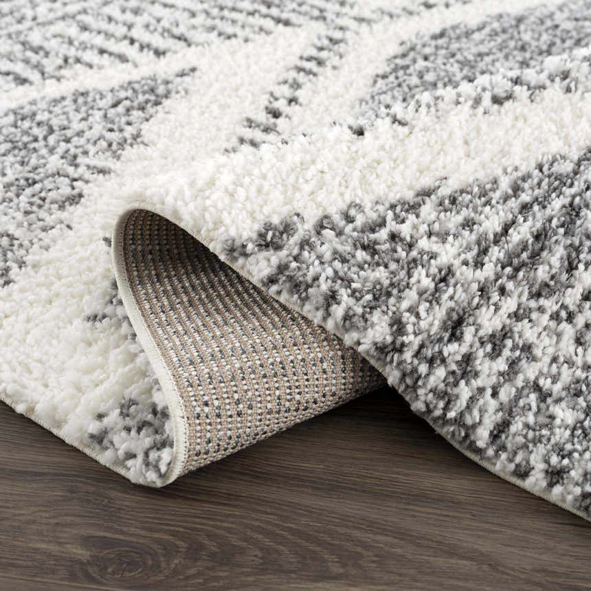 Close-up of the Trunding Plush Area Rug in charcoal and cream, showing the shag texture and machine-woven construction. Fold