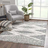 Living room scene with gray chair, plant, and the charcoal and cream Trunding Plush Area Rug. Roomscene-Rectangle