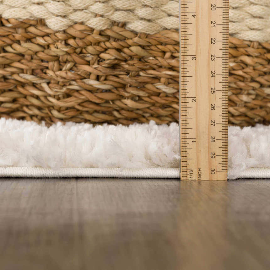Close up of the plush texture and pile height of the Hauteloom Trunding rug in light beige, with a ruler for scale. Pile