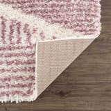 Close-up of the Trunding Plush in Pink Area Rug showing the shag texture, cream and pink colors, and rug backing. Fold