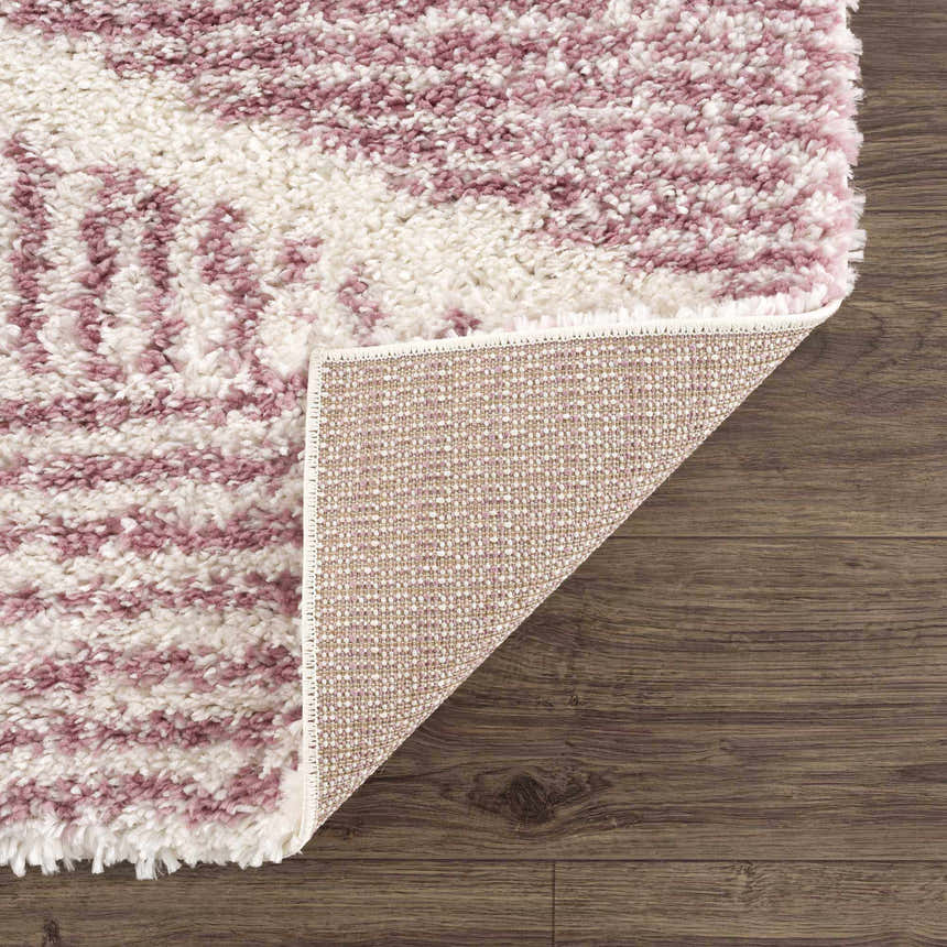 Close-up of the Trunding Plush in Pink Area Rug showing the shag texture, cream and pink colors, and rug backing. Fold