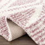 Close up of Trunding Plush pink area rug showing the shag texture and backing. Cream and pink rug detail. Fold