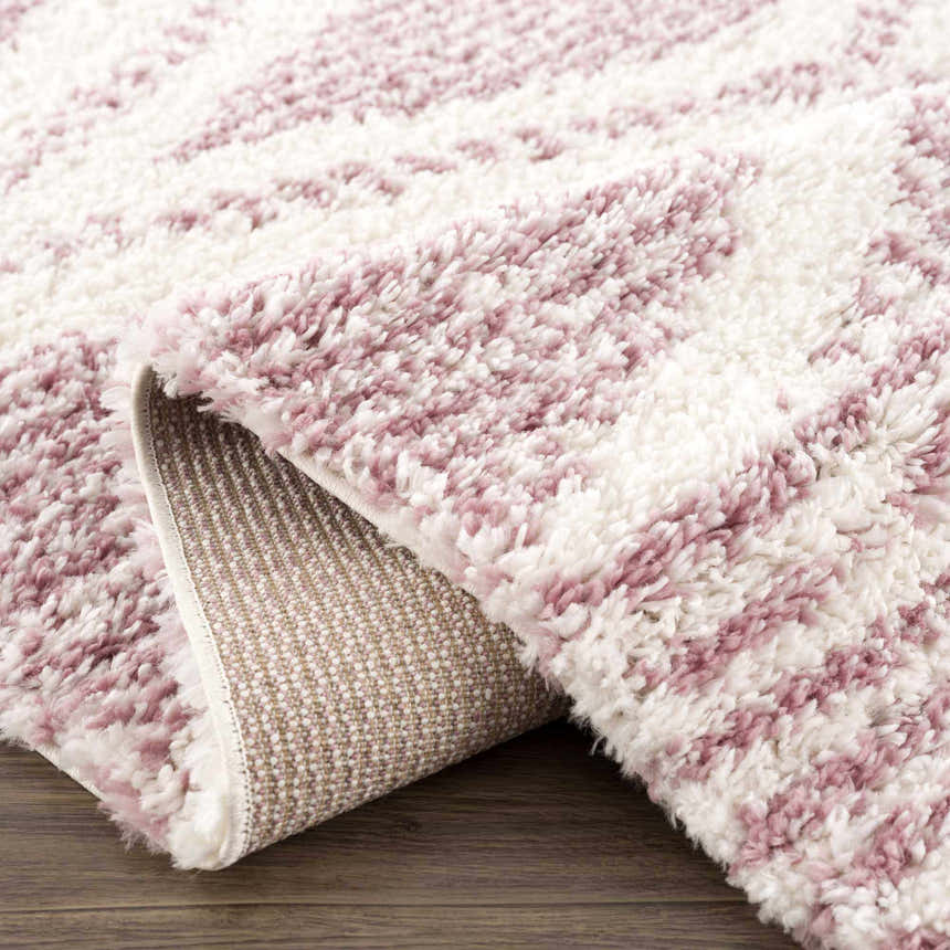 Close up of Trunding Plush pink area rug showing the shag texture and backing. Cream and pink rug detail. Fold
