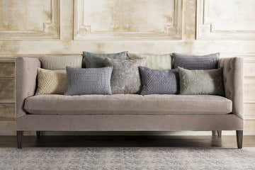 Living room scene with a Ronceverte Area Rug under a gray sofa with decorative throw pillows. Styleshot
