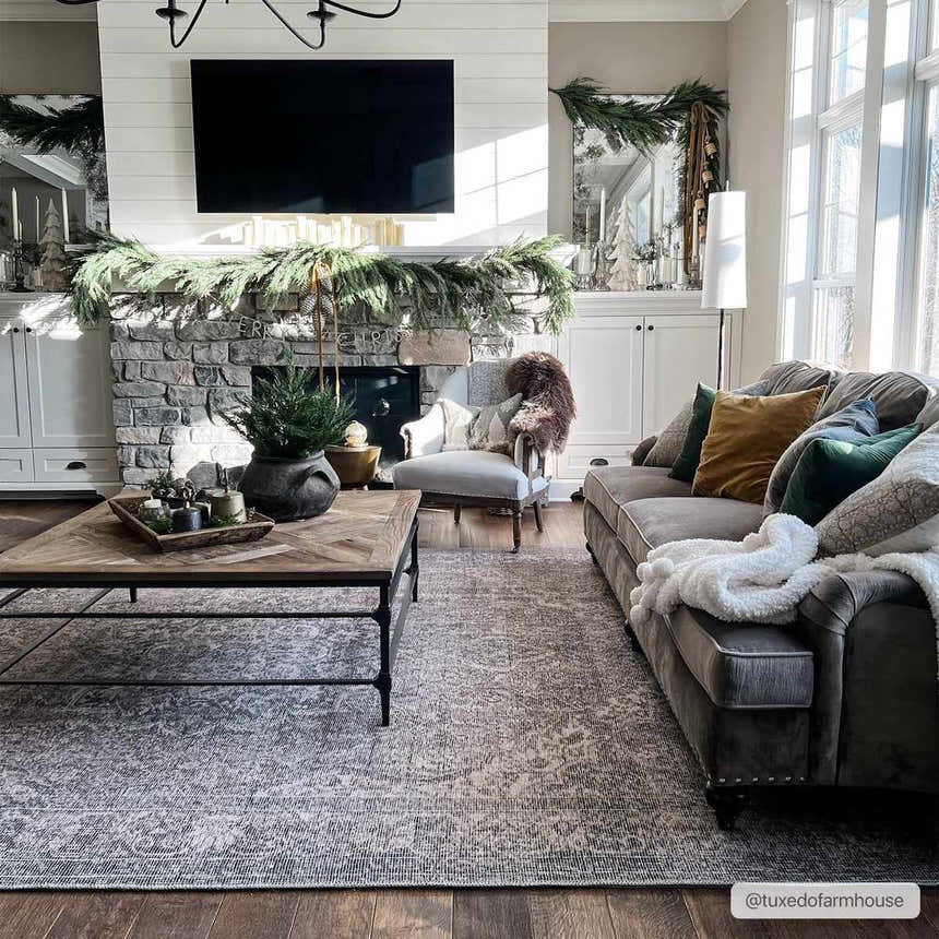 Living room with a Greenpoint Dusty Blue Washable Rug, stone fireplace, gray sofa, and wood coffee table. Christmas decor. Roomscene-Rectangle