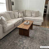 Living room scene with a Greenpoint Dusty Blue Washable Rug under a rustic wood coffee table and beige sectional sofa. Roomscene-Rectangle