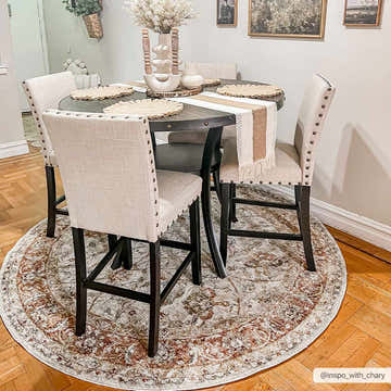 Farmhouse dining room with round table and Dyan Cream Textured Rug. Neutral tones and warm wood flooring. Roomscene-Round