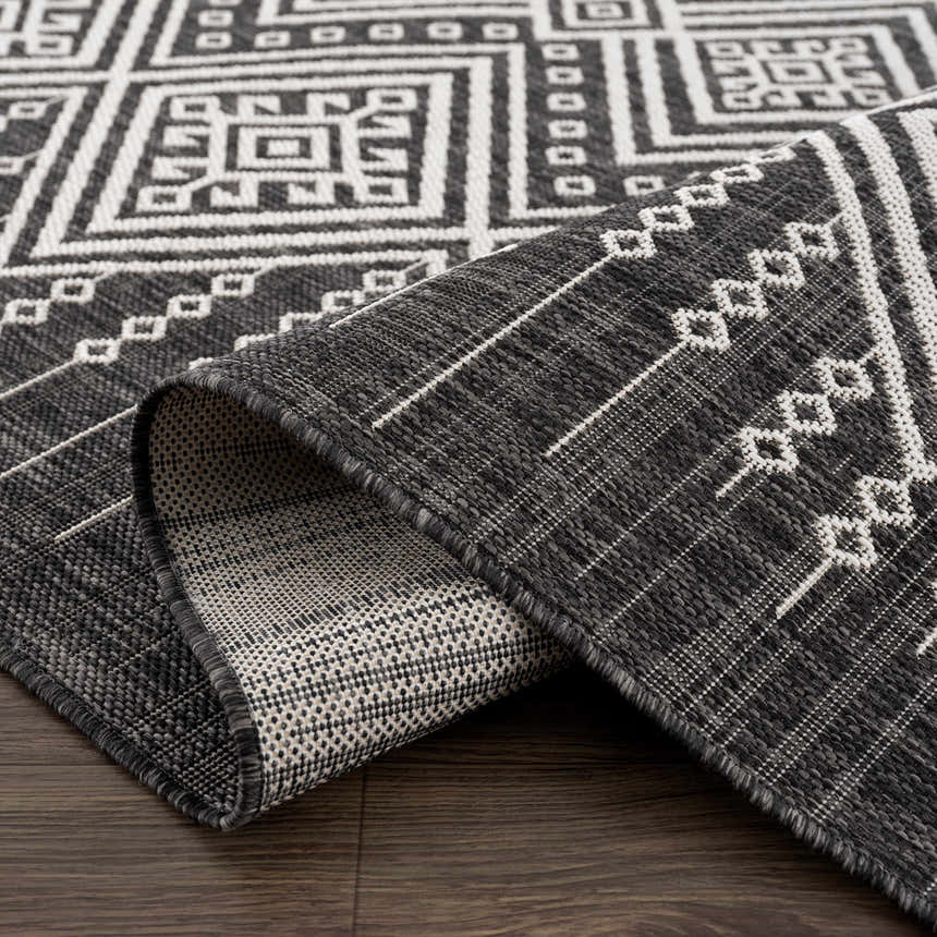 Close-up of the Frankville Black&White All Over Performance Rug. Features a bold geometric pattern and durable, low-pile construction. Fold