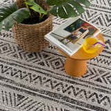 Close-up of the Catrine Indoor & Outdoor Rug showing its black, charcoal, and off-white bohemian pattern and woven texture. Styleshot