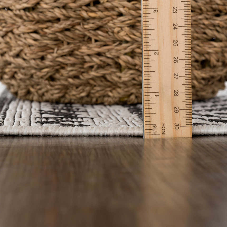 Close-up of the Catrine Indoor & Outdoor Rug showing the pile height, black and white pattern, and woven texture. Pile