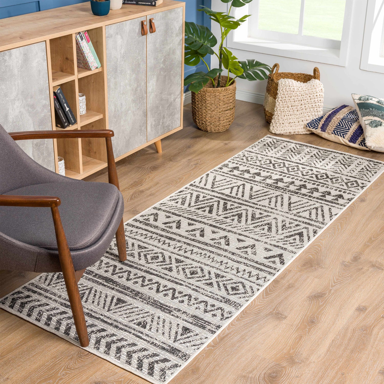 Living room scene with a gray chair and the black and white Catrine Indoor & Outdoor Runner Rug. Roomscene-Runner