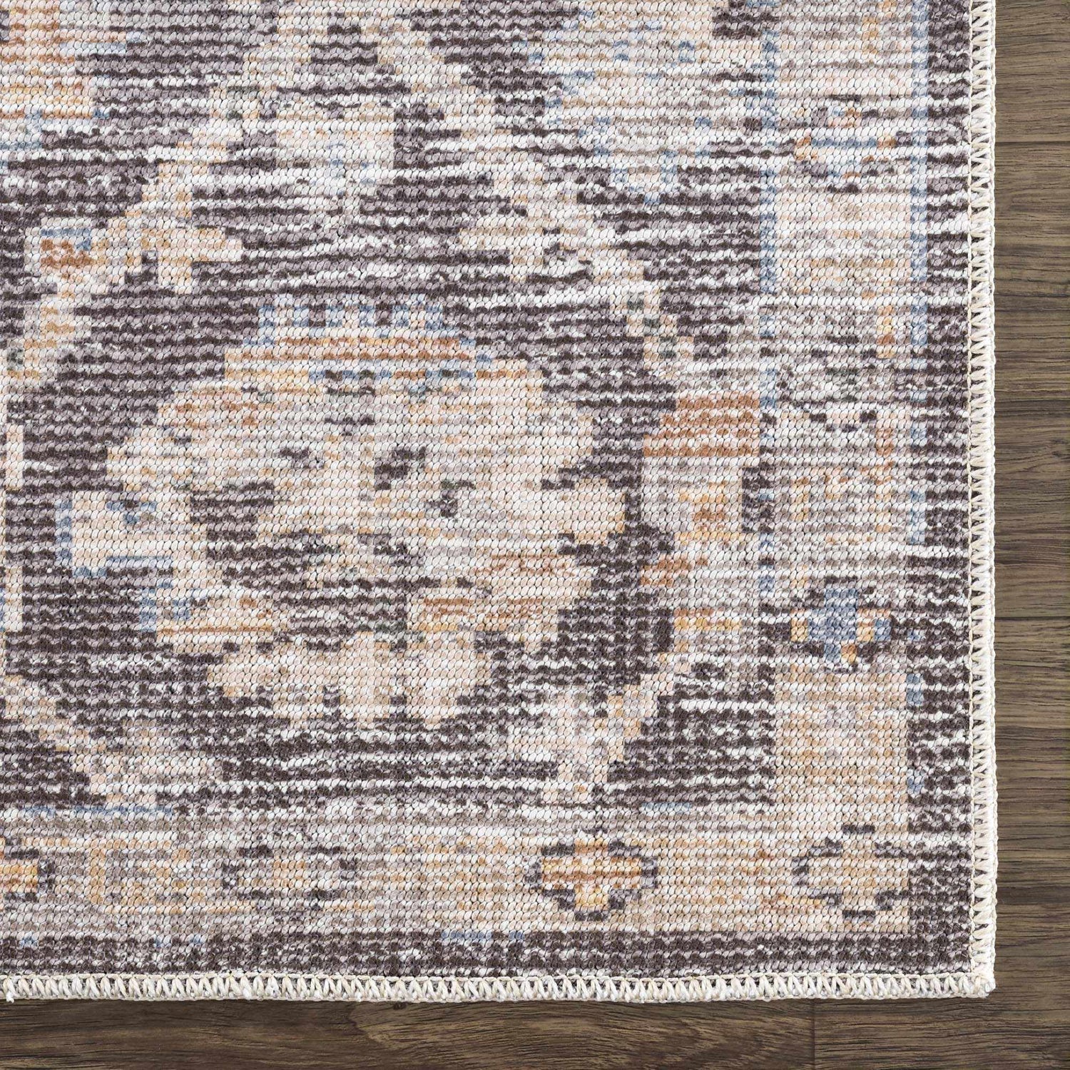 Close-up of the machine-woven Okoth Area Rug. Farmhouse style rug with brown, tan, and blue traditional pattern. Swatch
