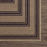 Close-up of Coty Washable Jutely Rug showing natural jute texture and charcoal geometric border pattern on dark wood floor. Swatch