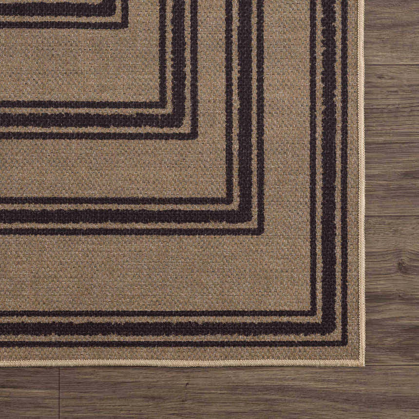 Close-up of Coty Washable Jutely Rug showing natural jute texture and charcoal geometric border pattern on dark wood floor. Swatch