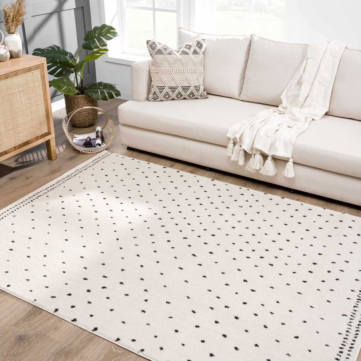 Living room scene with a Julie Area Rug, beige sofa, and wood cabinet. Polka dot rug adds a modern touch. Roomscene-Rectangle