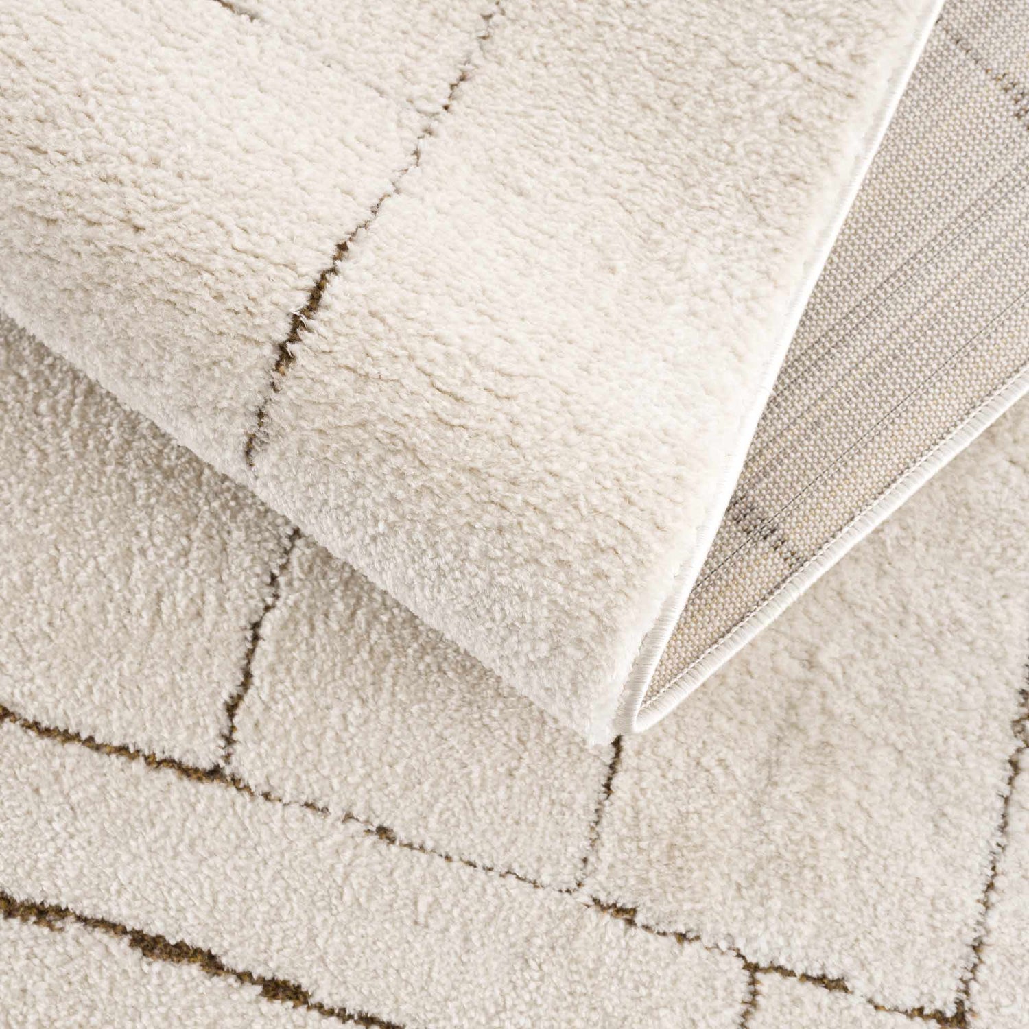 Close-up of the Keats Area Rug showing its plush beige pile, brown geometric pattern, and durable machine-woven construction. Fold