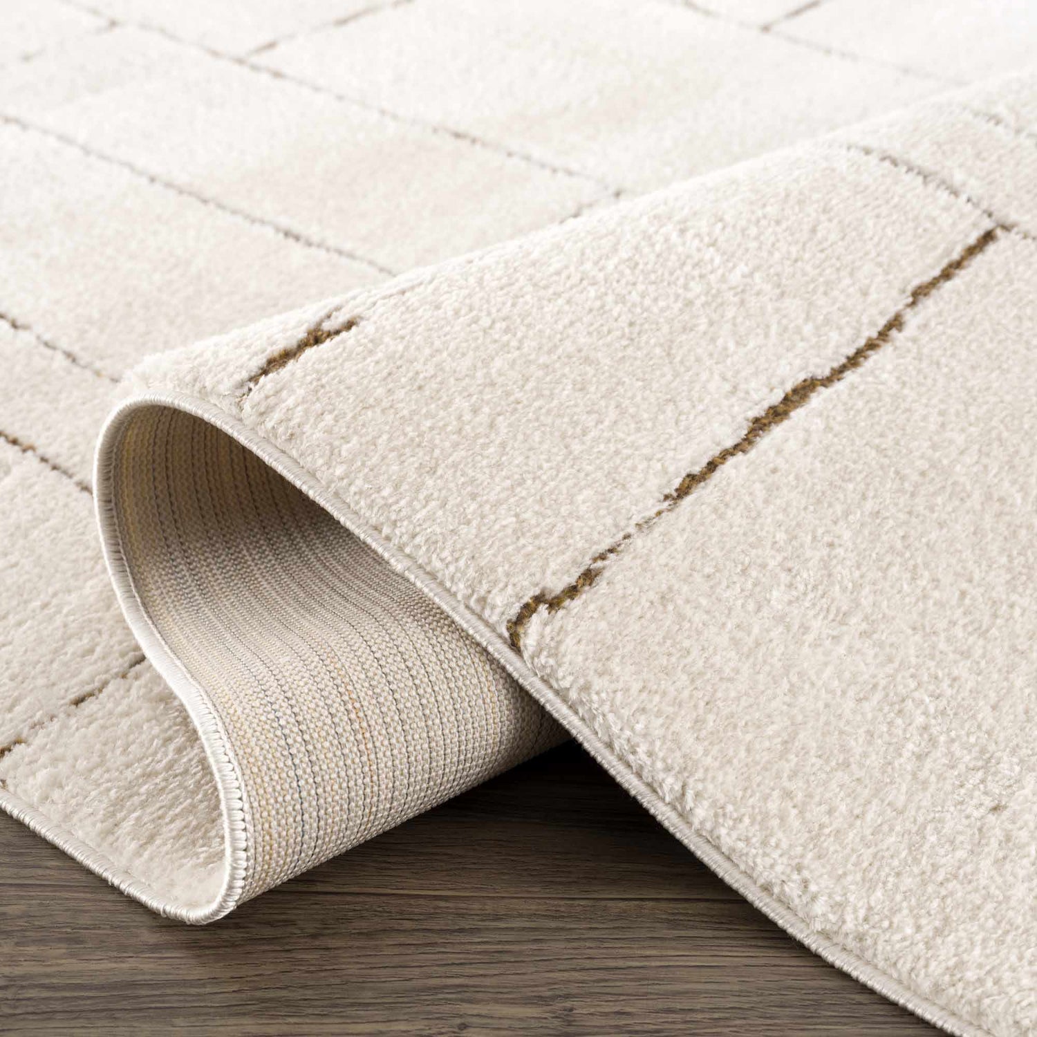 Close up of the beige Keats Area Rug showing geometric pattern and soft texture. Fold