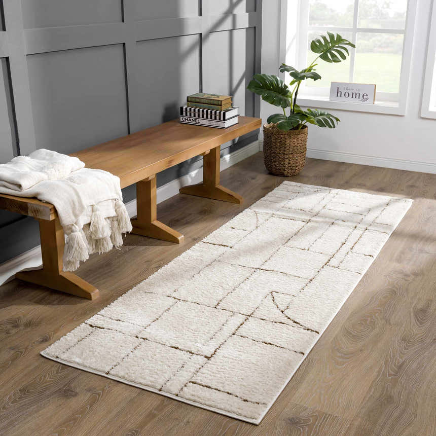 Entryway with a beige Keats Area Rug, wood bench, throw blanket, and monstera plant. Roomscene-Runner