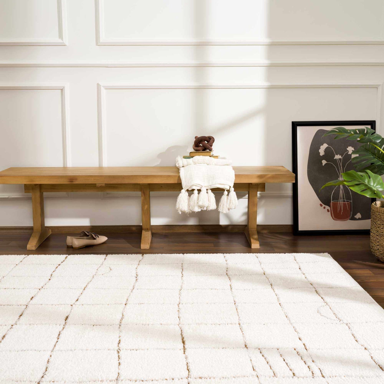 Entryway with a beige Keanu Area Rug, wooden bench, modern art, and a plant. Roomscene-Rectangle