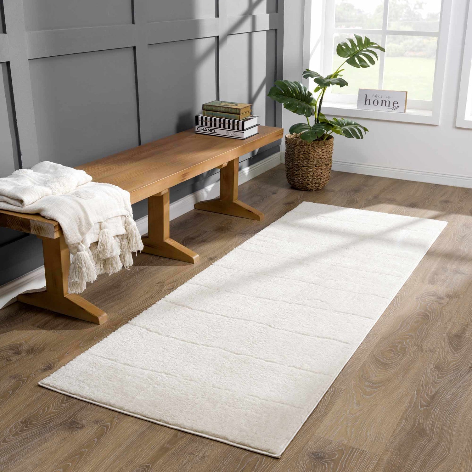 Entryway with a Keanu Ivory Area Rug runner, wood bench, and gray paneled wall. Roomscene-Runner