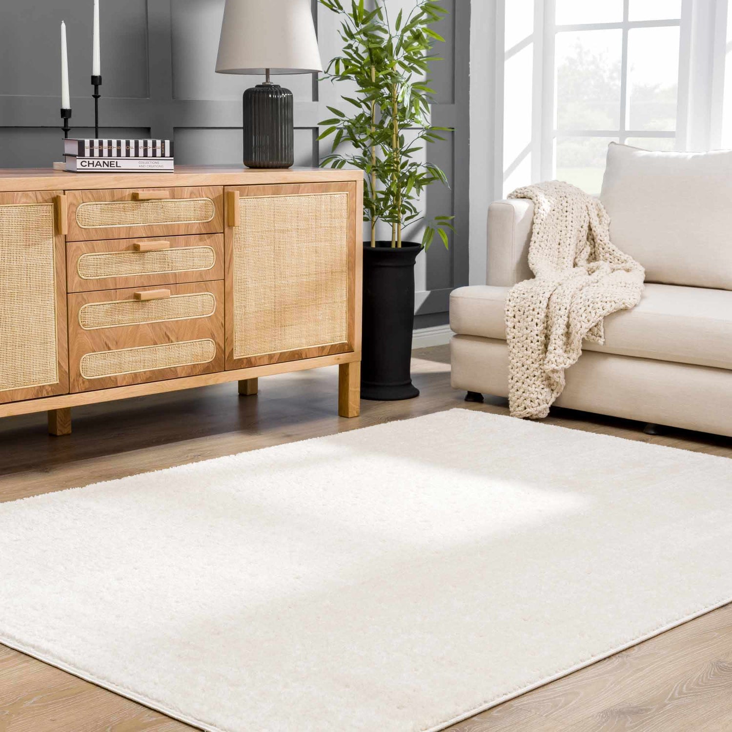 Living room scene with a Julie Ivory Area Rug, light wood cabinet, and cream sofa. Roomscene-Rectangle