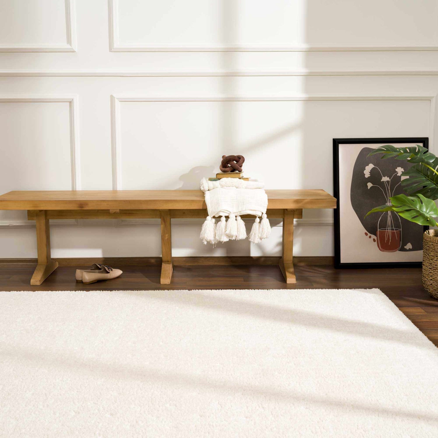 Entryway scene with a Julie Ivory Area Rug, wood bench, art, and plant. Roomscene-Rectangle