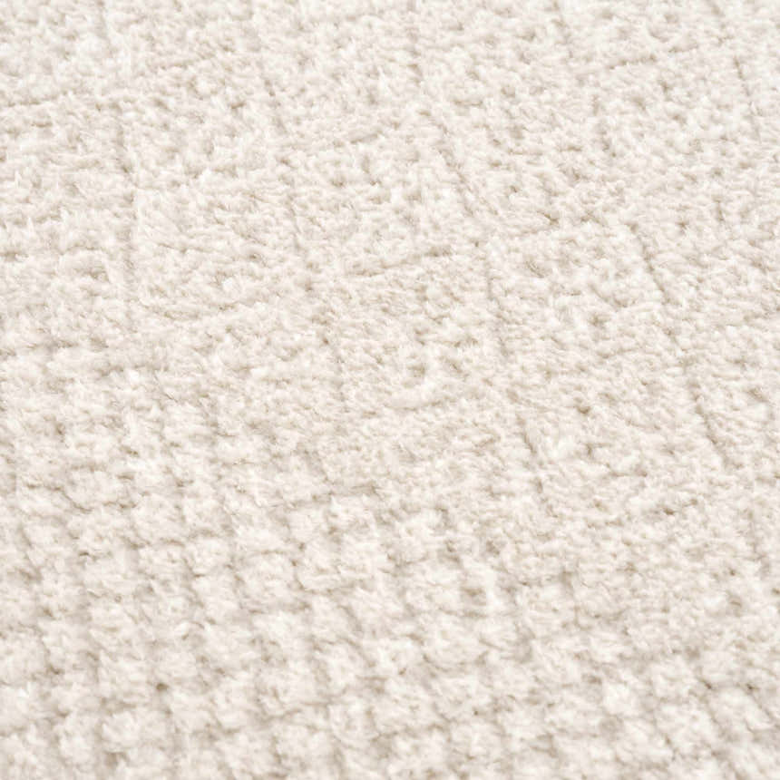 Close up of the textured, ivory pile of the Julio Ivory Area Rug. Texture