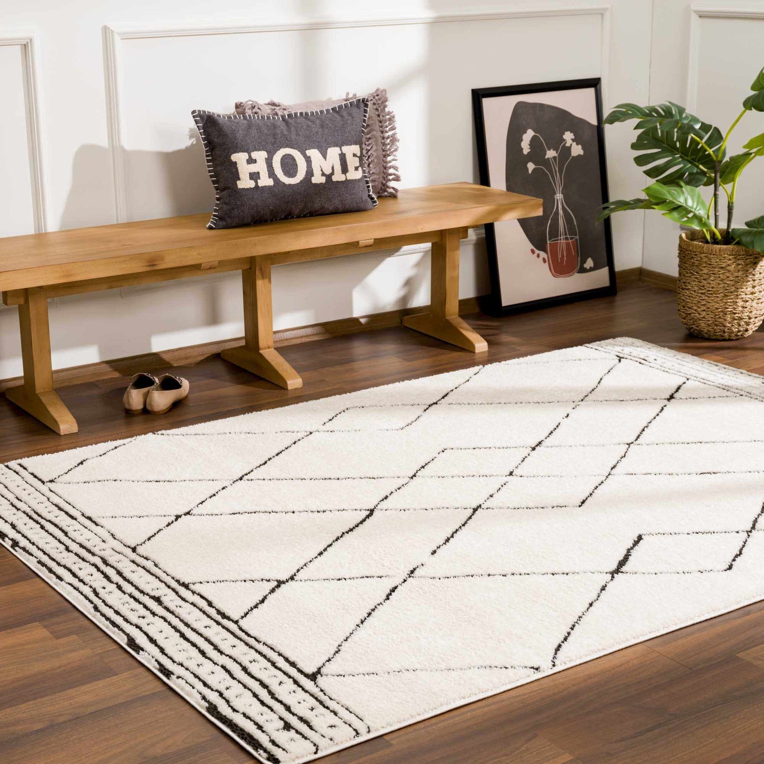 Entryway with a Keone Black & White Thick Rug, wood bench, HOME pillow, and houseplant for a modern farmhouse feel. Roomscene-Rectangle