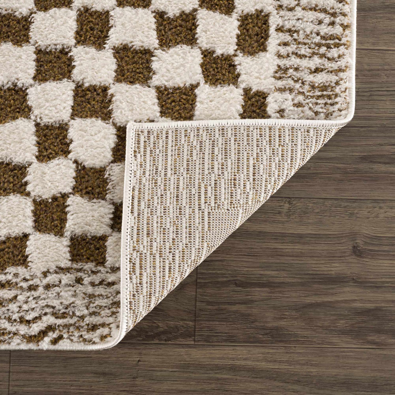 Close-up of Leryn Brown Checkered Plush Rug showing the brown and ivory checkered pattern and rug backing. Fold