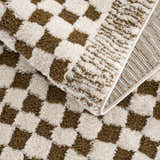 Close-up of the plush Leryn Brown Checkered Rug. Beige and brown checkered pattern, soft texture. Fold