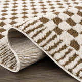 Close-up of the Leryn Brown Checkered Plush Rug, showcasing its geometric brown and ivory pattern and soft, plush texture. Fold