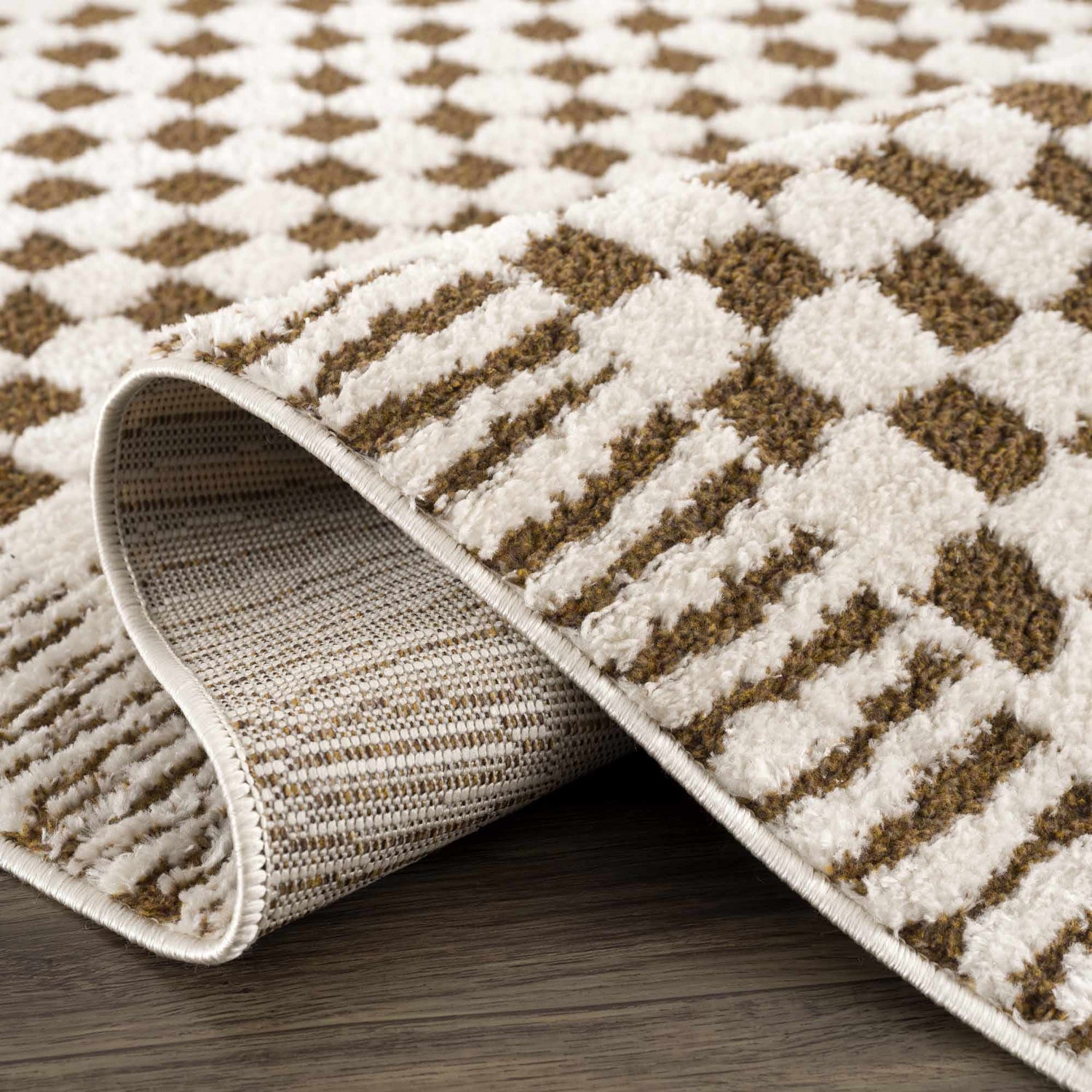 Close-up of the Leryn Brown Checkered Plush Rug, showcasing its geometric brown and ivory pattern and soft, plush texture. Fold