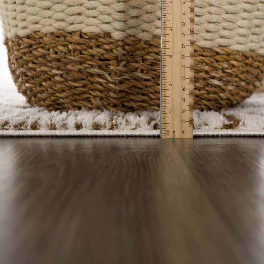 Close-up of the plush Leryn Brown Checkered Rug, showing its thickness with a ruler next to a woven basket. Pile