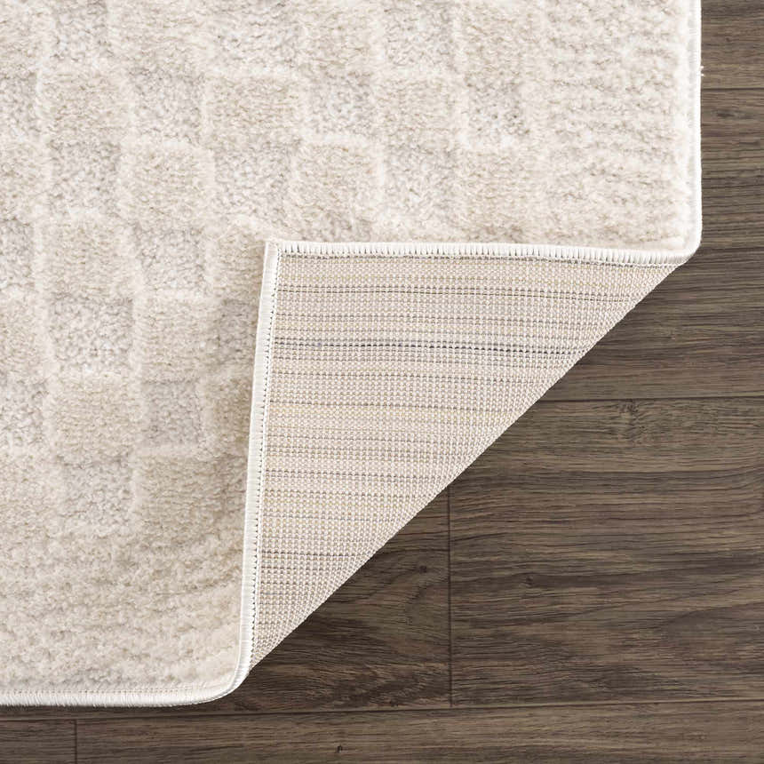 Close-up of the Leryn Ivory Checkered Area Rug showing its plush texture, checkered pattern, and woven backing on wood floor. Fold