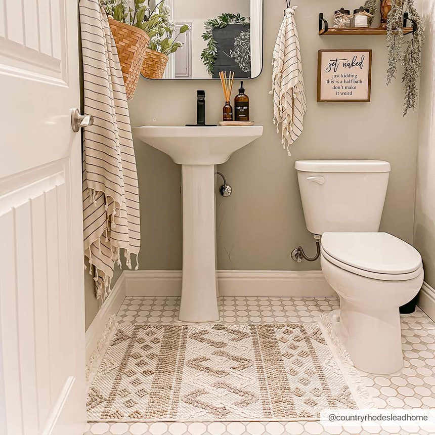 Farmhouse bathroom with beige Faruq Area Rug, white pedestal sink, toilet, and hexagon tile floor. Neutral, cozy style. Roomscene-Rectangle