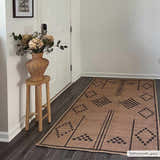 Entryway scene with Fathi Washable Area Rug in camel and brown. Farmhouse style with flowers and wood stool. Roomscene-Rectangle