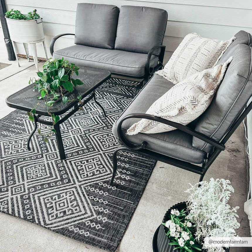 Cozy porch scene with gray seating on a Frankville Black&White All Over Performance Rug with a geometric pattern. Roomscene-Rectangle