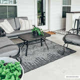 Outdoor patio scene with gray furniture and a black and white Frankville Performance Rug. Roomscene-Rectangle