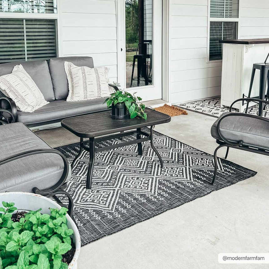 Outdoor patio scene with gray furniture and a black and white Frankville Performance Rug. Roomscene-Rectangle
