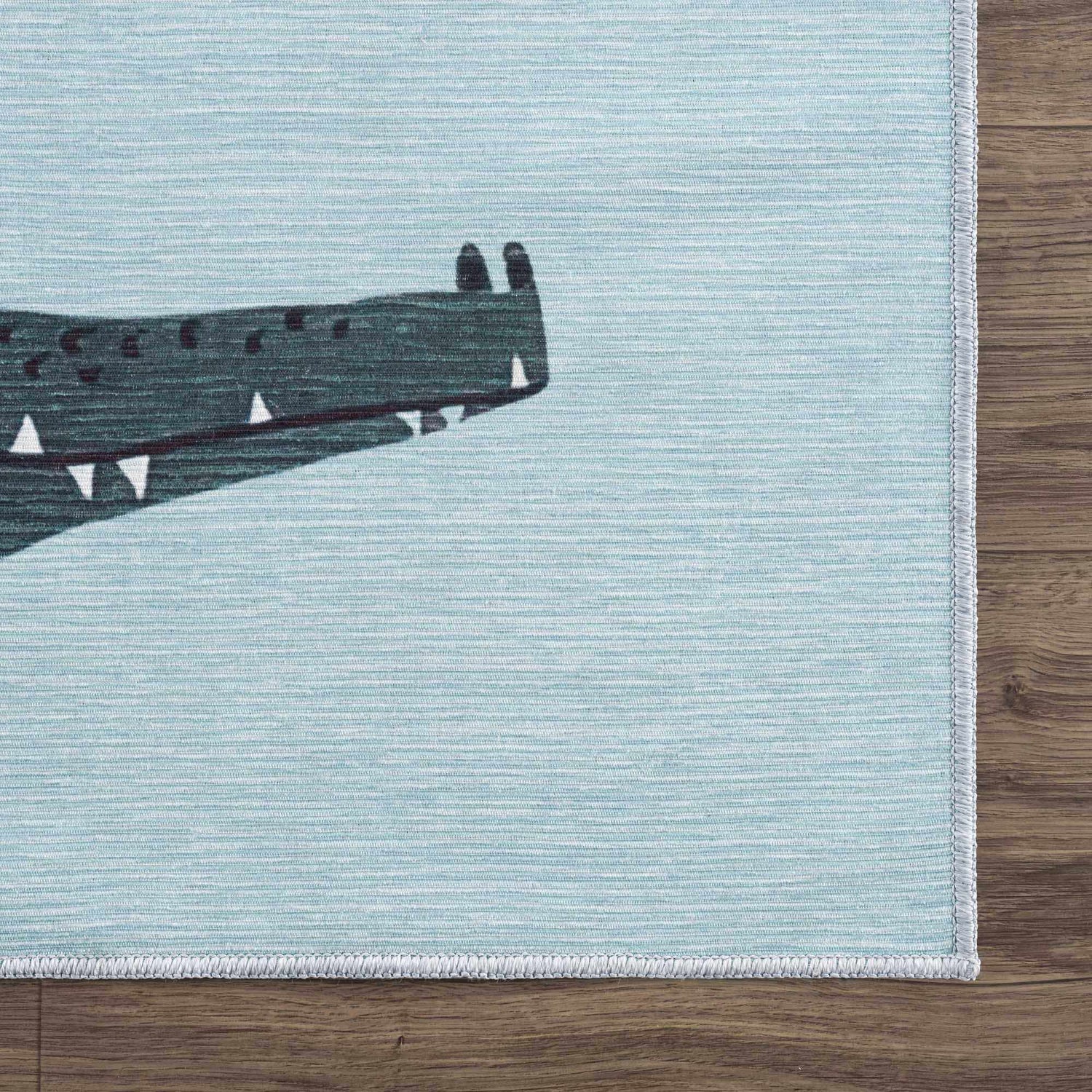 Close-up of the Petey Blue Animal Print Washable Kids Rug, featuring a cute alligator on an aqua blue background. Corner
