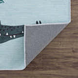 Close-up of the Petey Blue Animal Print Washable Kids Rug showing aqua, navy, and burnt orange crocodile design and rug backing. Fold
